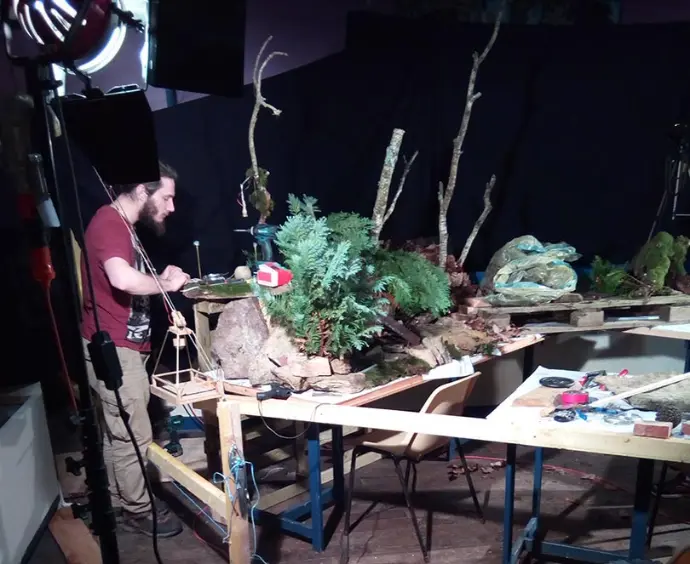 Une personne installe un décor pour un tournage de stop motion